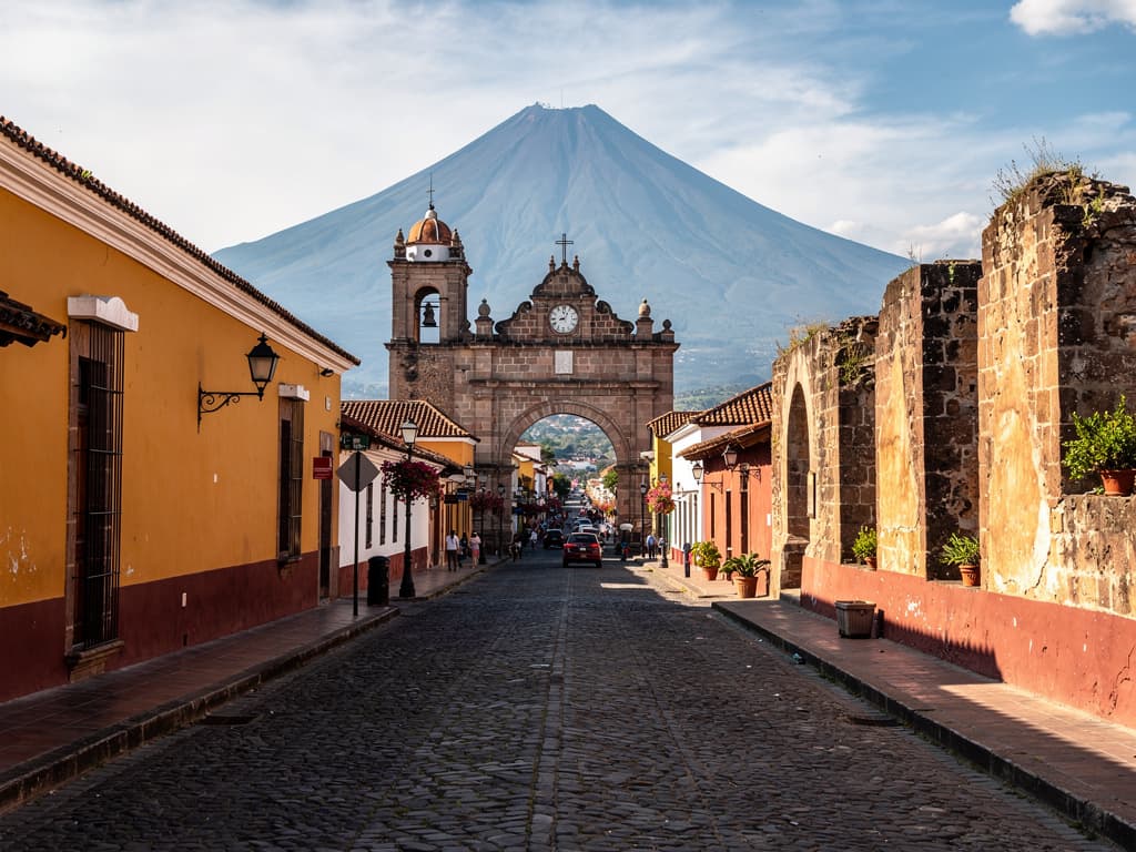 Volcán Agua rising at the end of Quinta Avenida, southern light across the cobbles